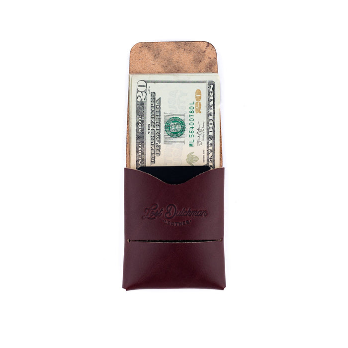 Brown leather money clip with a dollar bill inside on a white background