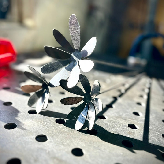 Metallic flower-shaped objects on a perforated metal surface