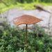 Decorative metal leaf sculpture in a garden setting
