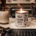 Candle labeled 'Leather Smith' on a workbench with tools in the background