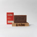 Bar of Klenr soap on a wooden block with a red box labeled Klenr in the background.