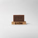 Brown bar of soap on a wooden stand with 'KLENR' branding on a light gray background