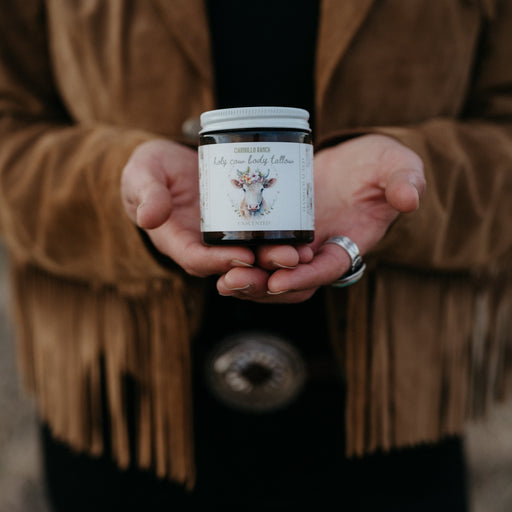 Person holding a jar of cream with a blurred background