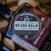Beard balm packaging with a label on a wooden background