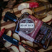 Beard balm with packaging on a wooden surface with apples and a knife.