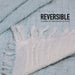 Reversible fabric with white fringe on a light blue background, featuring text about thickness.