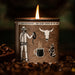 Candle in a container with a cowboy and coffee design, surrounded by coffee beans.