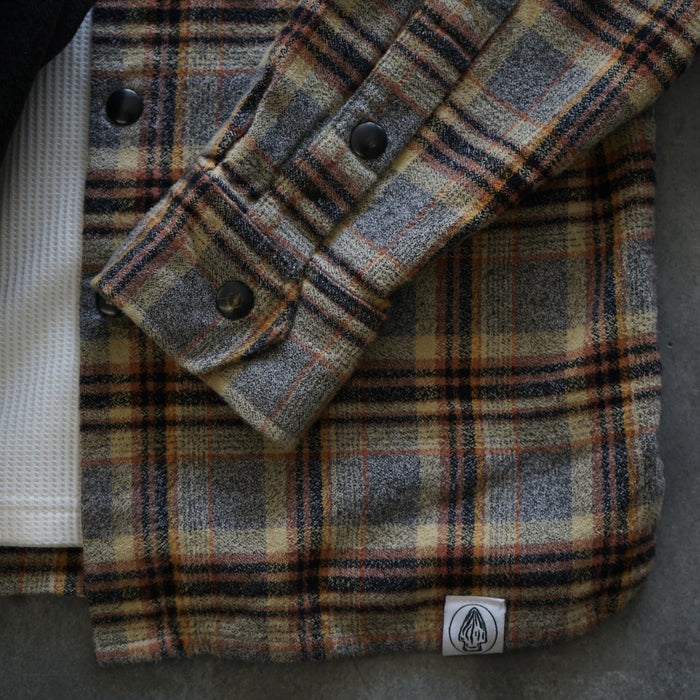 Plaid jacket with a brand logo on a dark background
