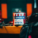 Candle in a container labeled 'All American Motor Oil' on a wooden surface with a blurred background.