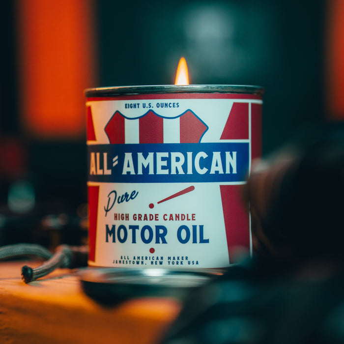 Candle in a can labeled 'All American Pure High Grade Candle Motor Oil' with a flame.