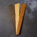 Three wooden spatulas on a dark textured surface