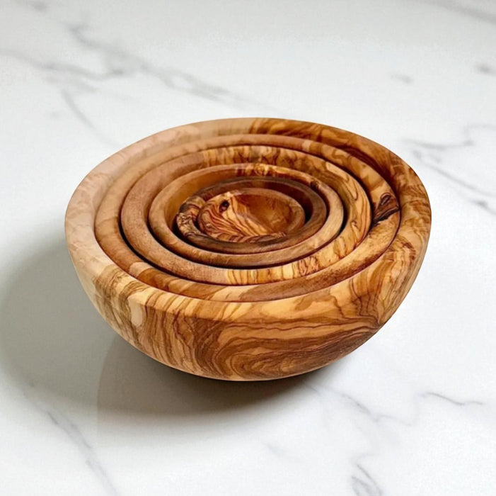 Set of wooden bowls with concentric designs on a marble surface
