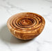 Set of wooden bowls with concentric designs on a marble surface