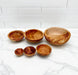 Set of wooden bowls on a marble surface with a white tiled wall background