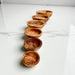 Set of wooden bowls arranged in a line on a marble surface