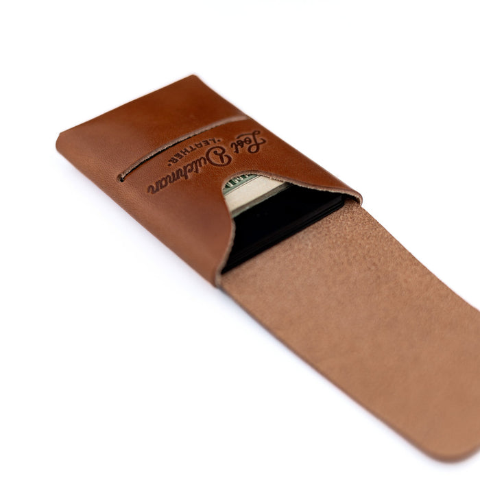 Brown leather money clip with brand name on a white background