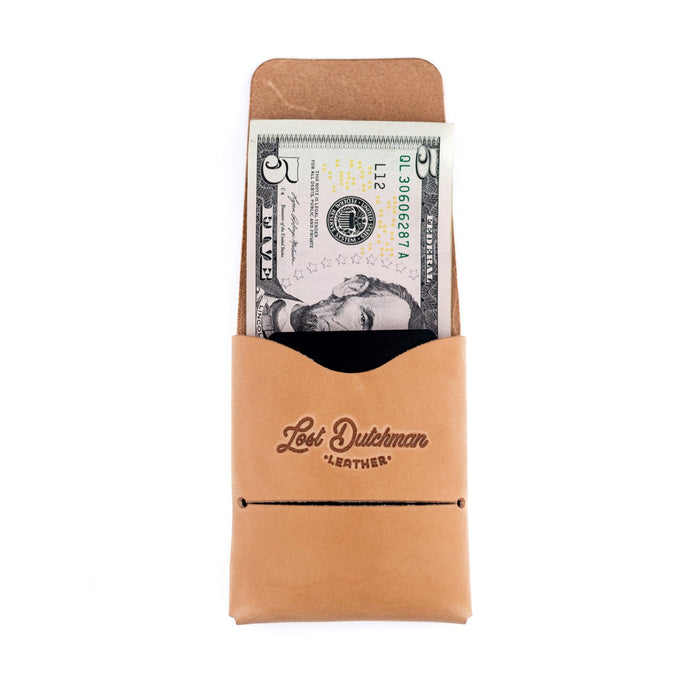 Tan leather wallet with a dollar bill inside, branded 'Lost Dutchman Leather', on a white background.