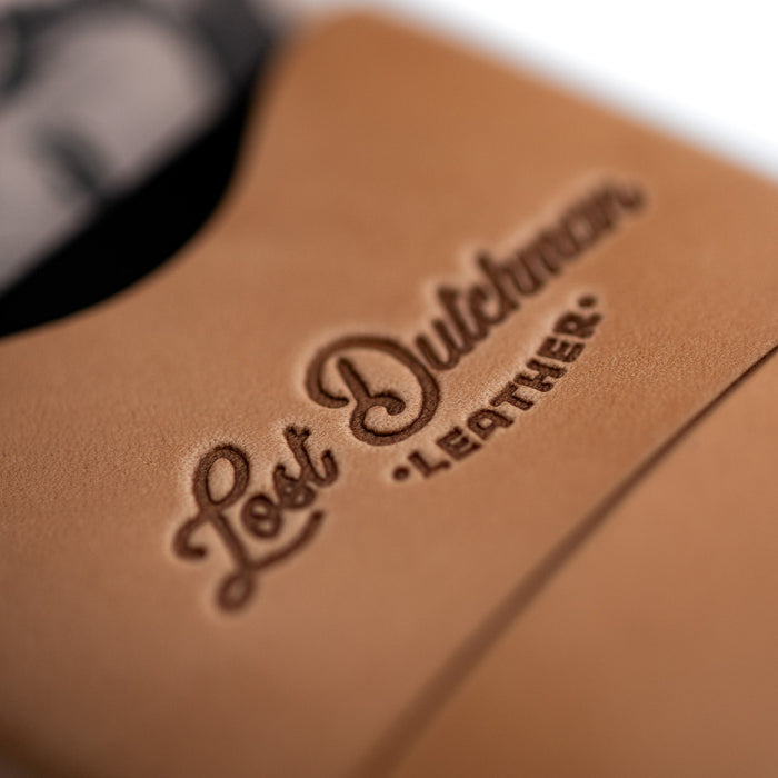 Close-up of 'Lost Dutchman Leather' embossed on brown leather surface