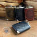 Four leather-flask set with embossed designs on a wooden surface, featuring 'Made in the USA' label.