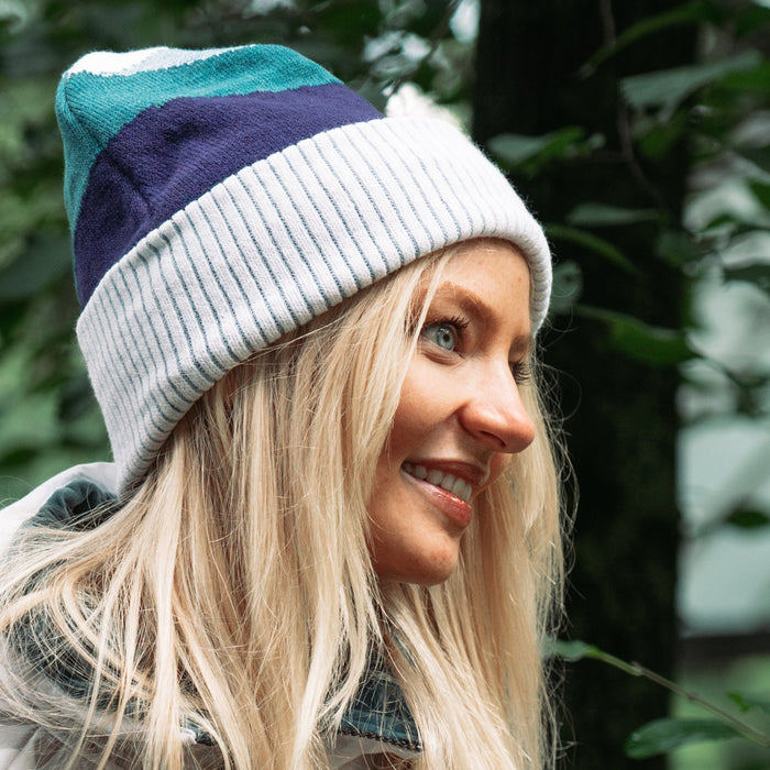 Woman wearing a colorful beanie with a blurred green background