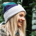 Woman wearing a colorful beanie with a blurred green background