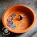Terracotta dish with coins and a ring, featuring 'Handmade in the USA for a Lifetime' branding.