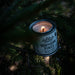 Candle in a can labeled 'Northern Pines' inside a pine tree