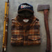 Fishing rod, plaid shirt, cap, and axe on a concrete surface