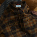Plaid shirt with a brand label on a brown leather couch