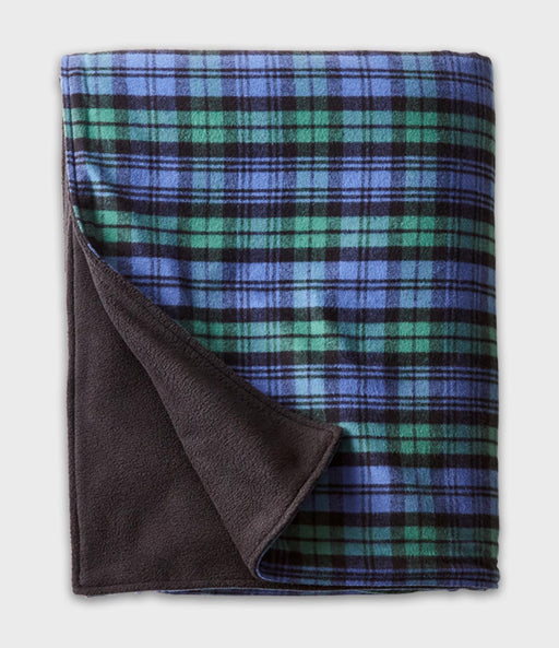 A folded plaid blanket with a blue, green, and black tartan pattern and a dark brown sherpa fleece backing, shown on a light gray background.