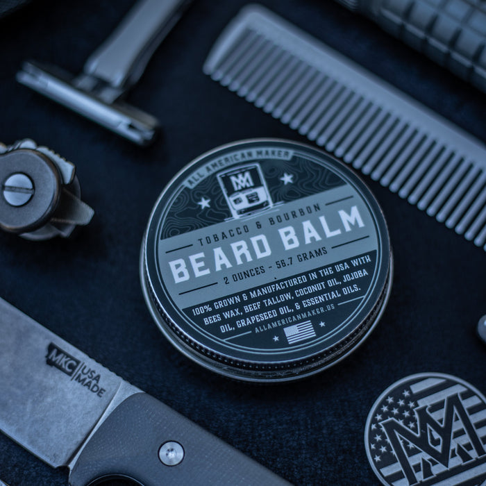 Beard balm container with grooming tools on a dark surface