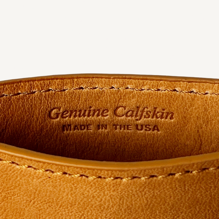 Close-up of brown leather with 'Genuine Calfskin Made in the USA' stamp
