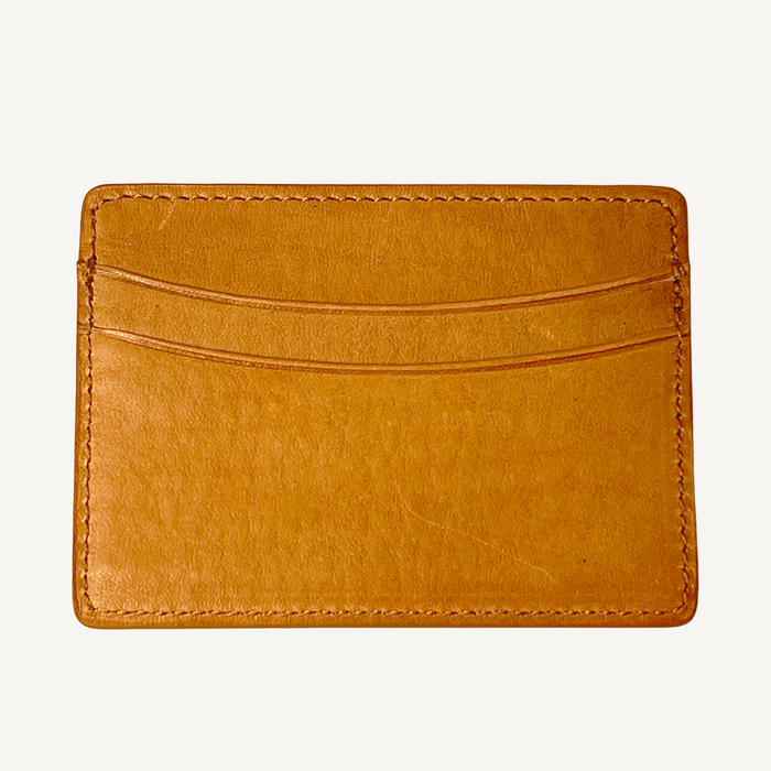 Brown leather cardholder on a light beige background