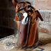 Set of leather gun holsters in a glass container with 'Handmade in the USA' label.