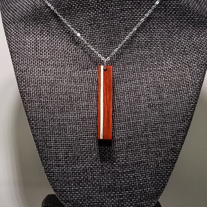 Necklace with a wooden pendant on a textured surface
