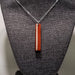 Necklace with a wooden pendant on a textured surface