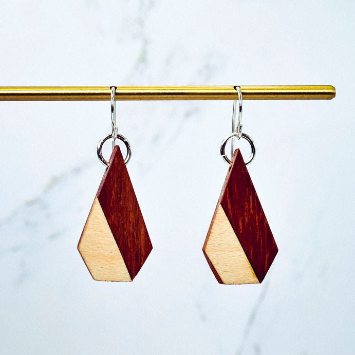 Wooden earrings with geometric design on a marble background
