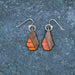 Wooden earrings on a textured gray surface