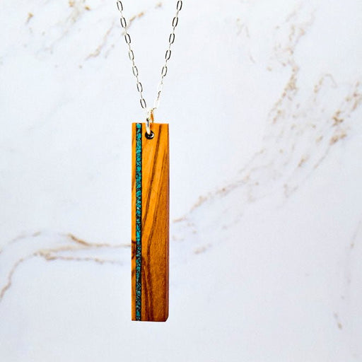 Necklace with a wooden pendant on a marble background