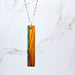 Necklace with a wooden pendant on a marble background