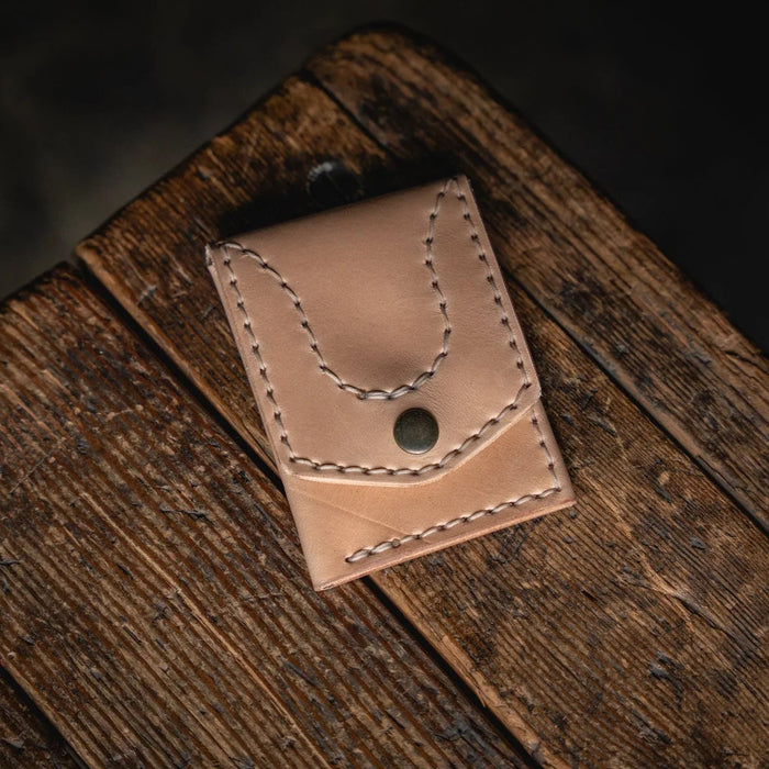 Brown leather pouch on a wooden surface