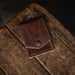 Brown leather wallet on a wooden surface with a dark background
