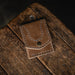 Brown leather wallet on a wooden surface with a dark background
