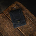 Black leather wallet on a wooden surface with a dark background