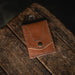 Brown leather pouch with stitching detail on a wooden surface