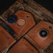 Brown leather key holder with metal keyring on a wooden surface