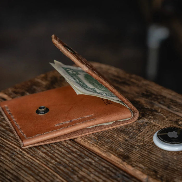 Brown leather wallet with money on a wooden surface