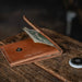 Brown leather wallet with money on a wooden surface