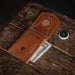 Brown leather wallet with money on a wooden surface