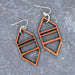 Geometric earrings on a textured gray surface